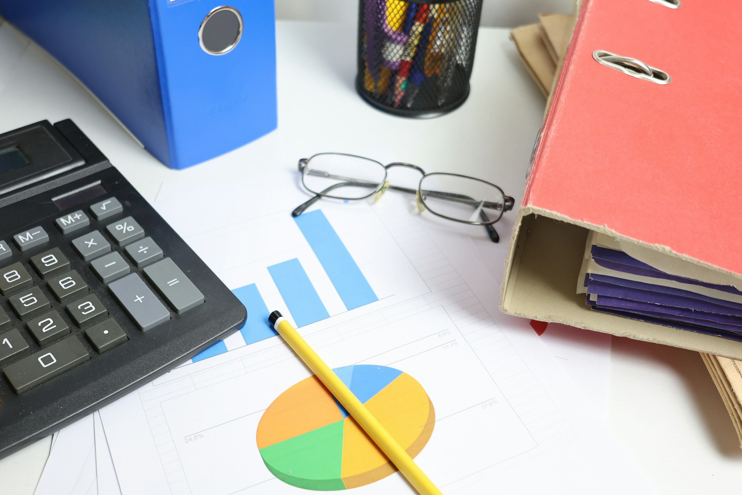 Organização de documentos e pastas contábeis com calculadora e gráficos